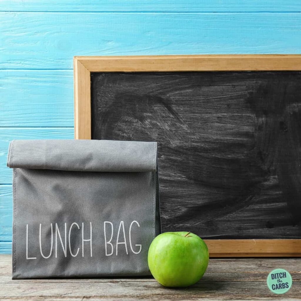 gray lunch bag with granny apple and chalkboard in the background